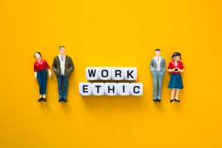 miniature-figure-with-work-ethic-words-on-yellow-b-2023-10-04-15-42-59-utc